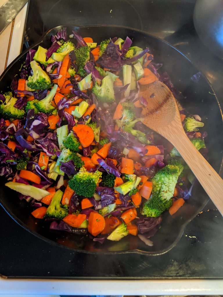 carrots, broccoli, and cabbage in a cast iron pan