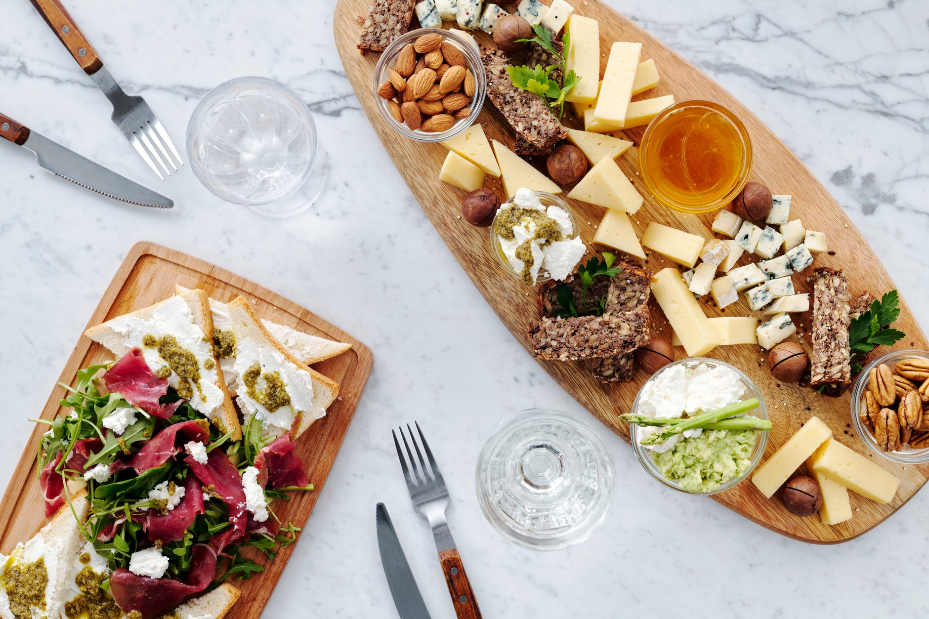 sliced bread with sliced vegetables and cheese on brown wooden chopping board
