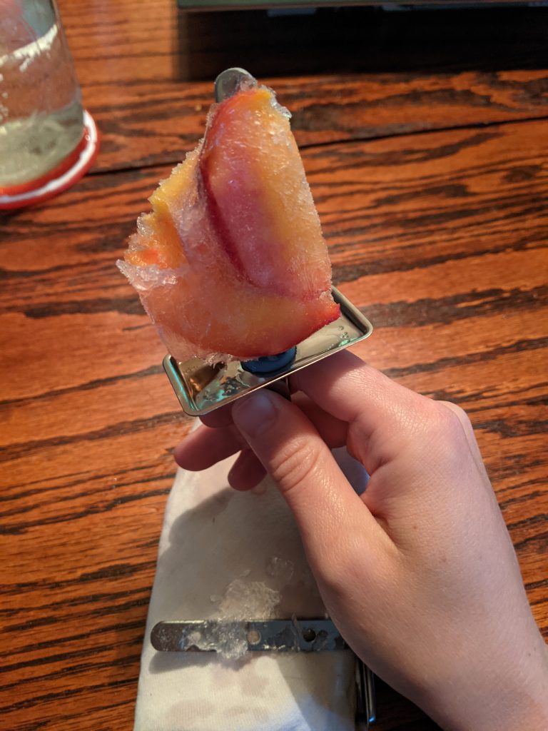Half eaten popsicle - icy with peaches
