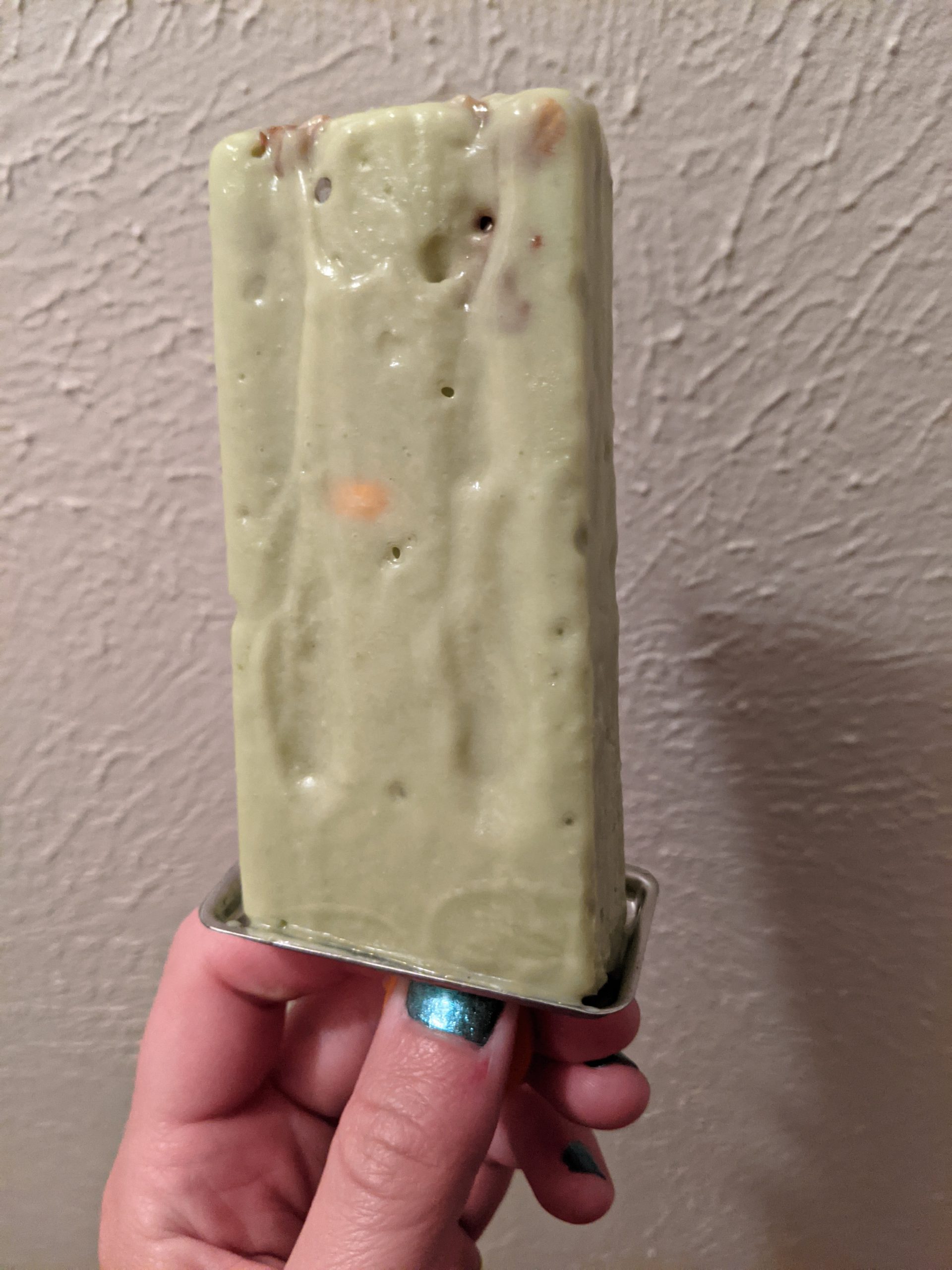 light green popsicle with crumbs in it