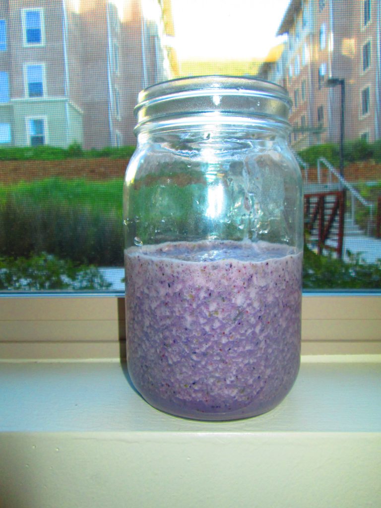 Purple smoothie in a jar on a windowsill