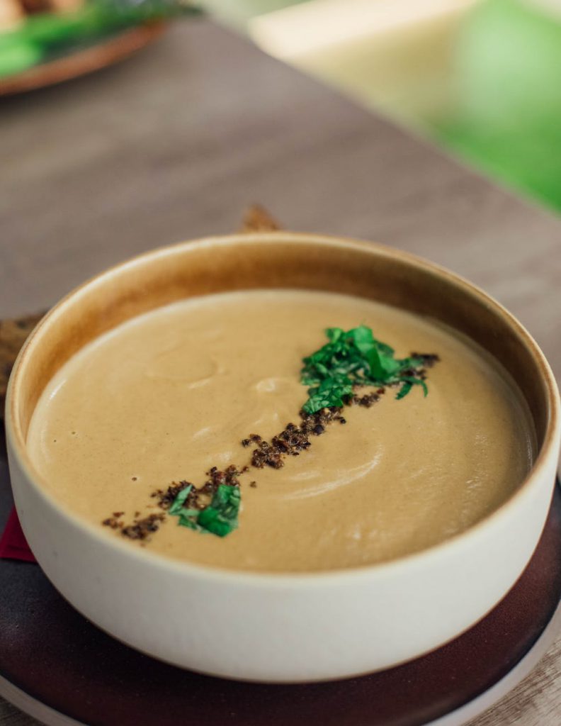 soup in a bowl with spice and herb garnish